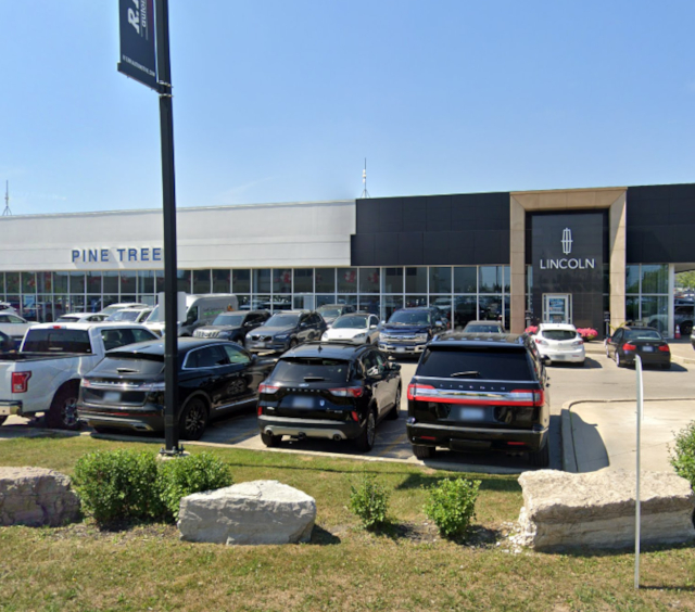 Lincoln dealership exterior with parked cars, showcasing modern automotive selection.